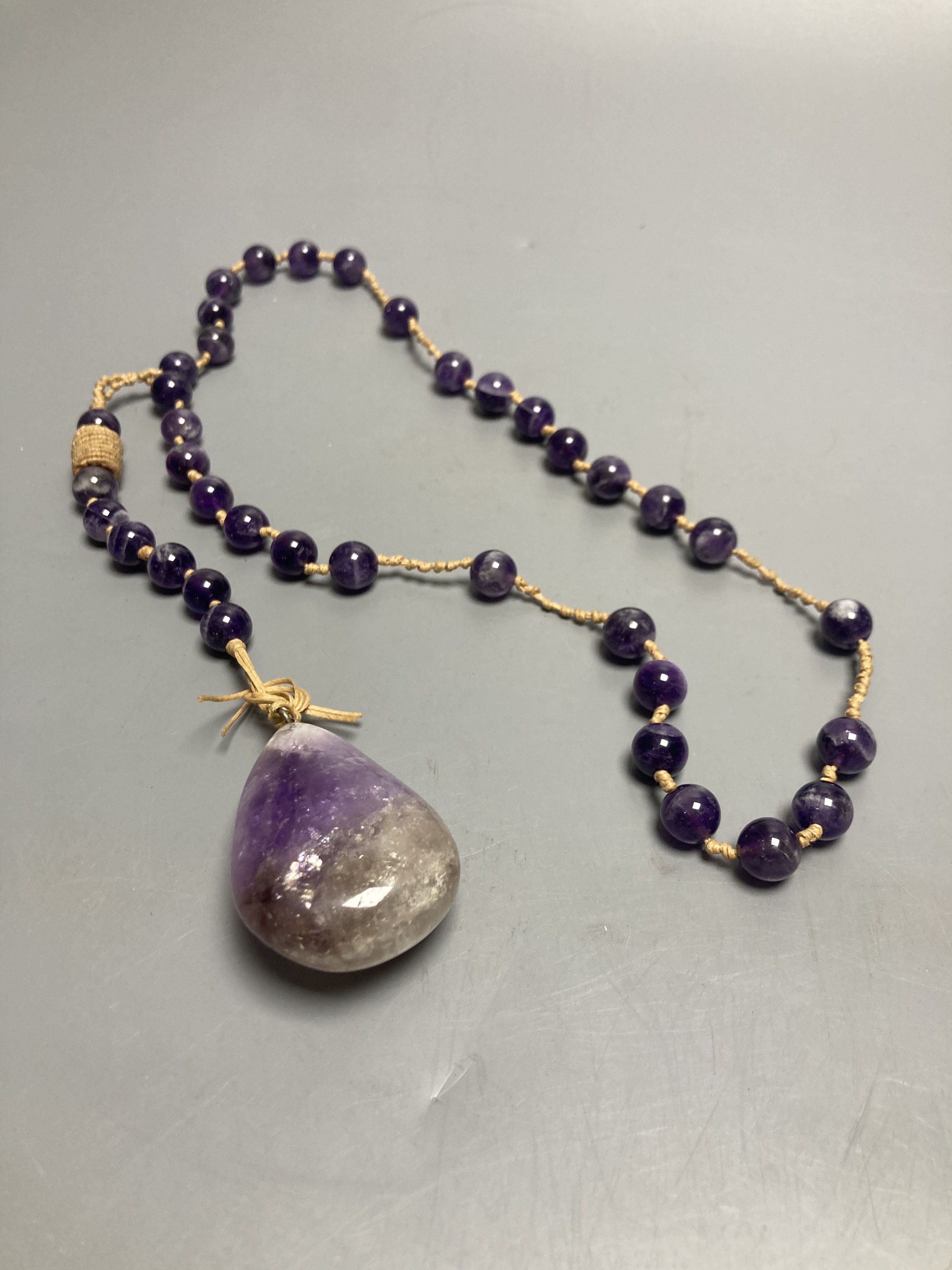 An amethyst bead necklace with amethyst pebble pendant.